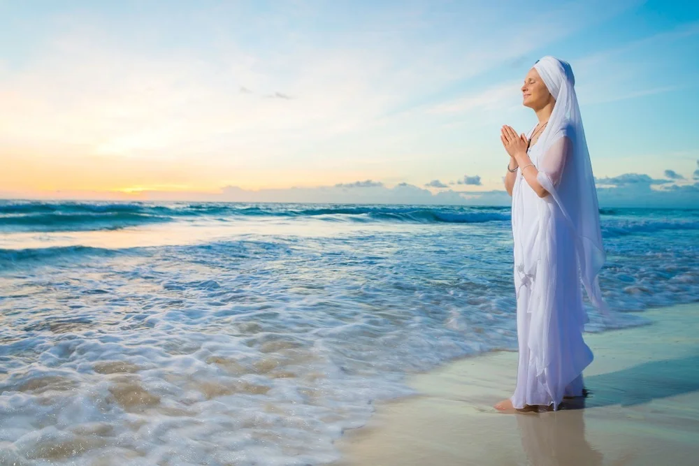 Snatam Kaur performing sacred music at sunset on the beach
